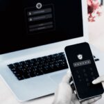 person using MFA on their phone to login to their laptop
