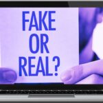 laptop displaying image of a person holding a fake or real message