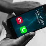 person holding a cell phone showing spam caller