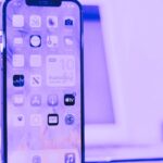 smart phone with laptop in background