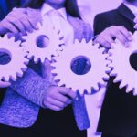 Business people holding gears representing a system