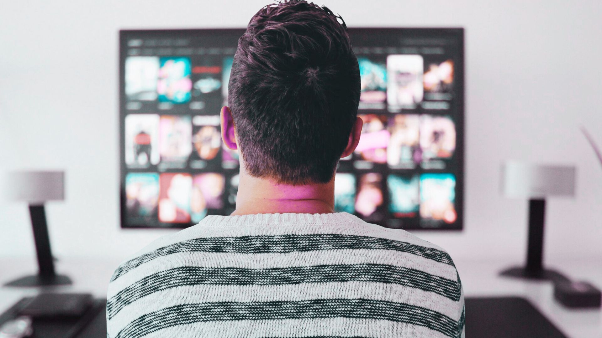 person sitting on the sofa and watching tv