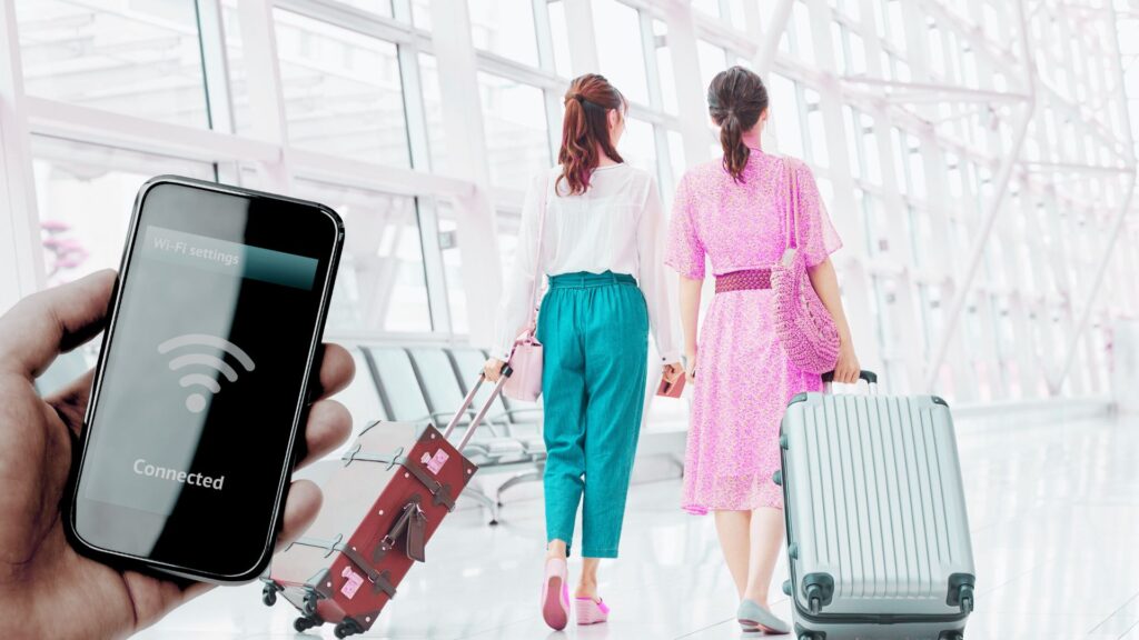 People in an airport and someone connecting to free Wi-Fi from their phone